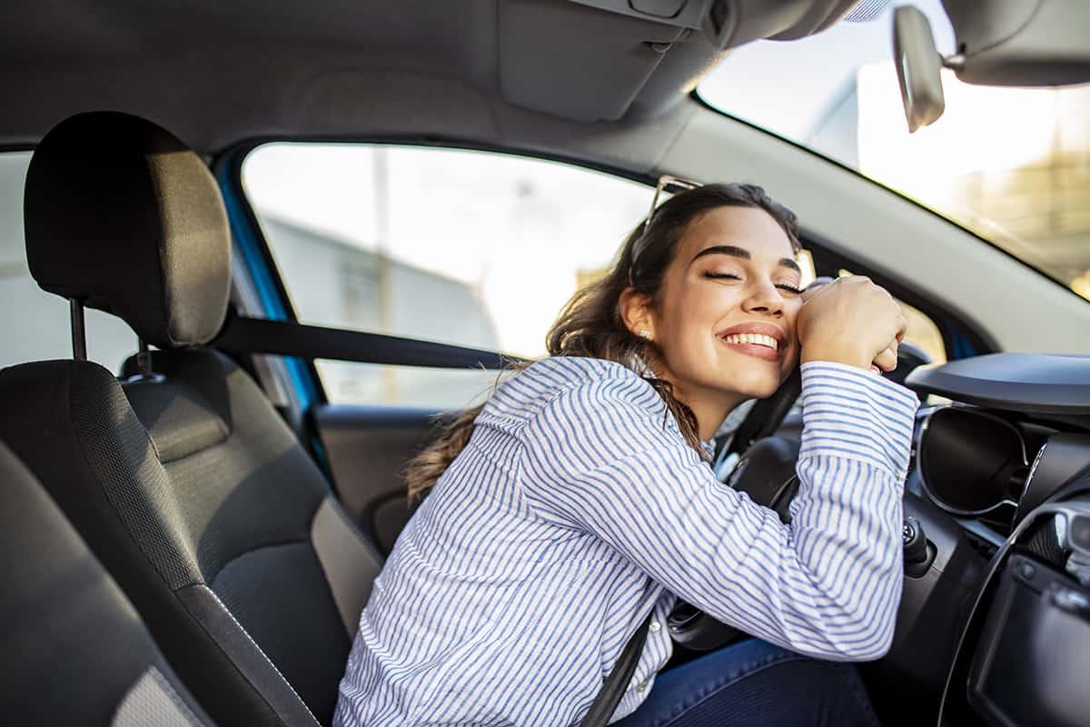 A happy driver sitting in her newly insured car